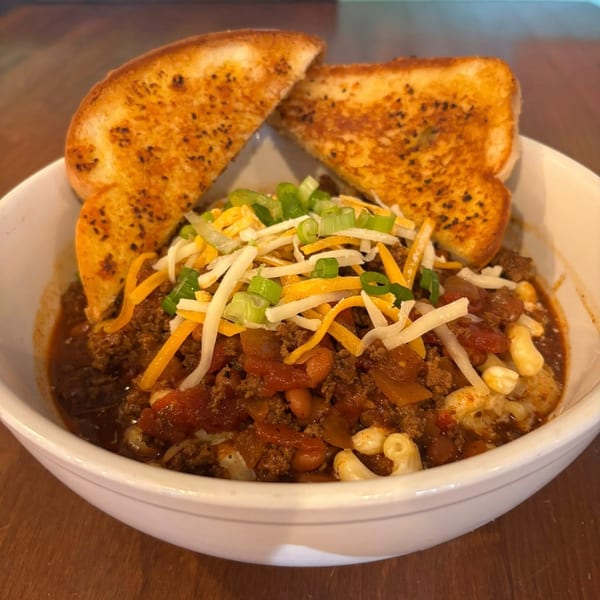 TJ's chili mac with shredded cheese, green onions, and two slices of garlic bread.