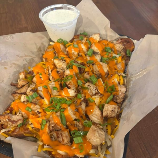 TJ's Burgers, Wings, and Pizza's loaded fries with chicken, cheese, buffalo sauce, and green onions.